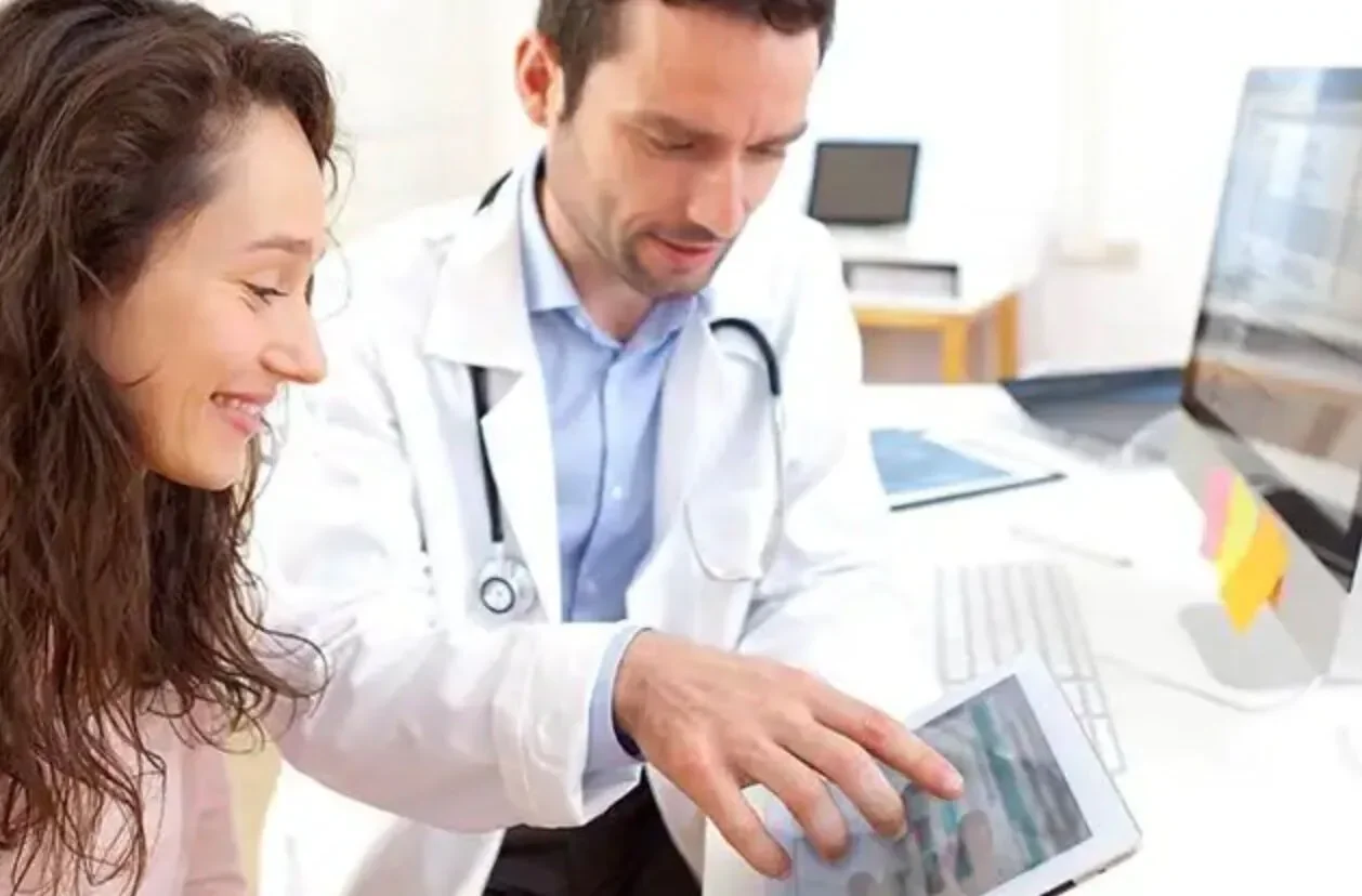 Doctor mostrando a una paciente su información protegida en la tablet