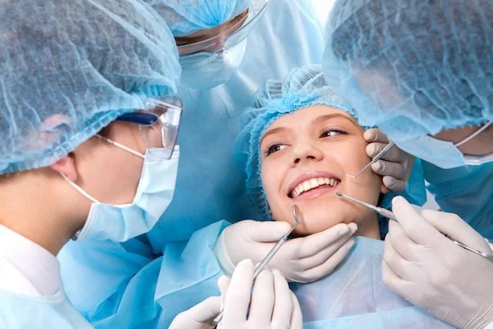 Equipo de cirugía oral operando a una paciente en el quirófano dental
